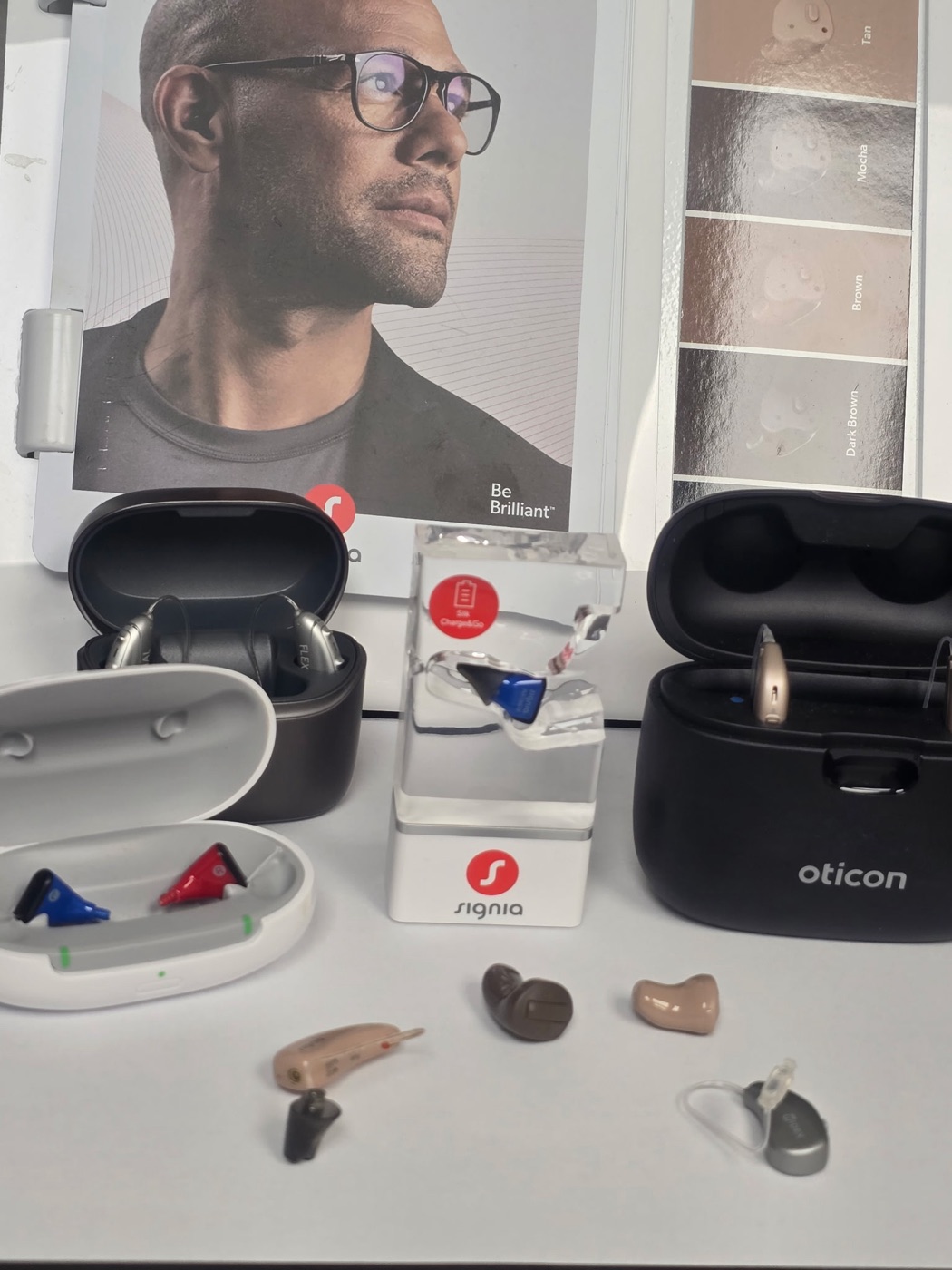 Hearing aid styles and charging cases on display at Elite Audiology PC in Great Neck, New York